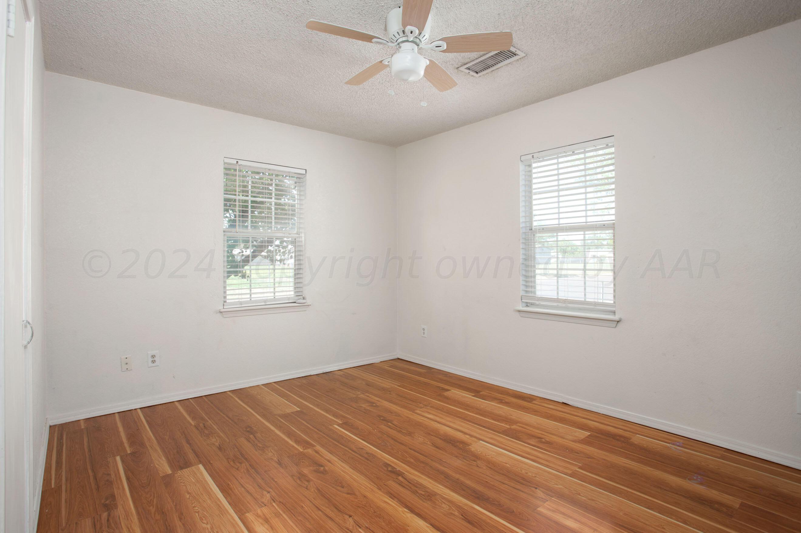 4625 South Travis Street Amarillo, TX 79110 - Photo 15 of 24 a view of a room with wooden floor and windows