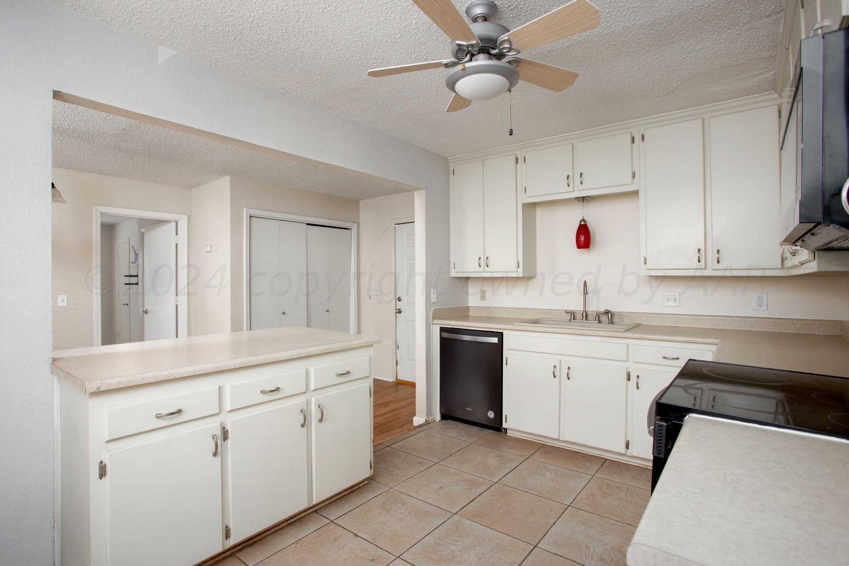 4625 South Travis Street Amarillo, TX 79110 - Photo 6 of 24 a kitchen with white cabinets and white appliances