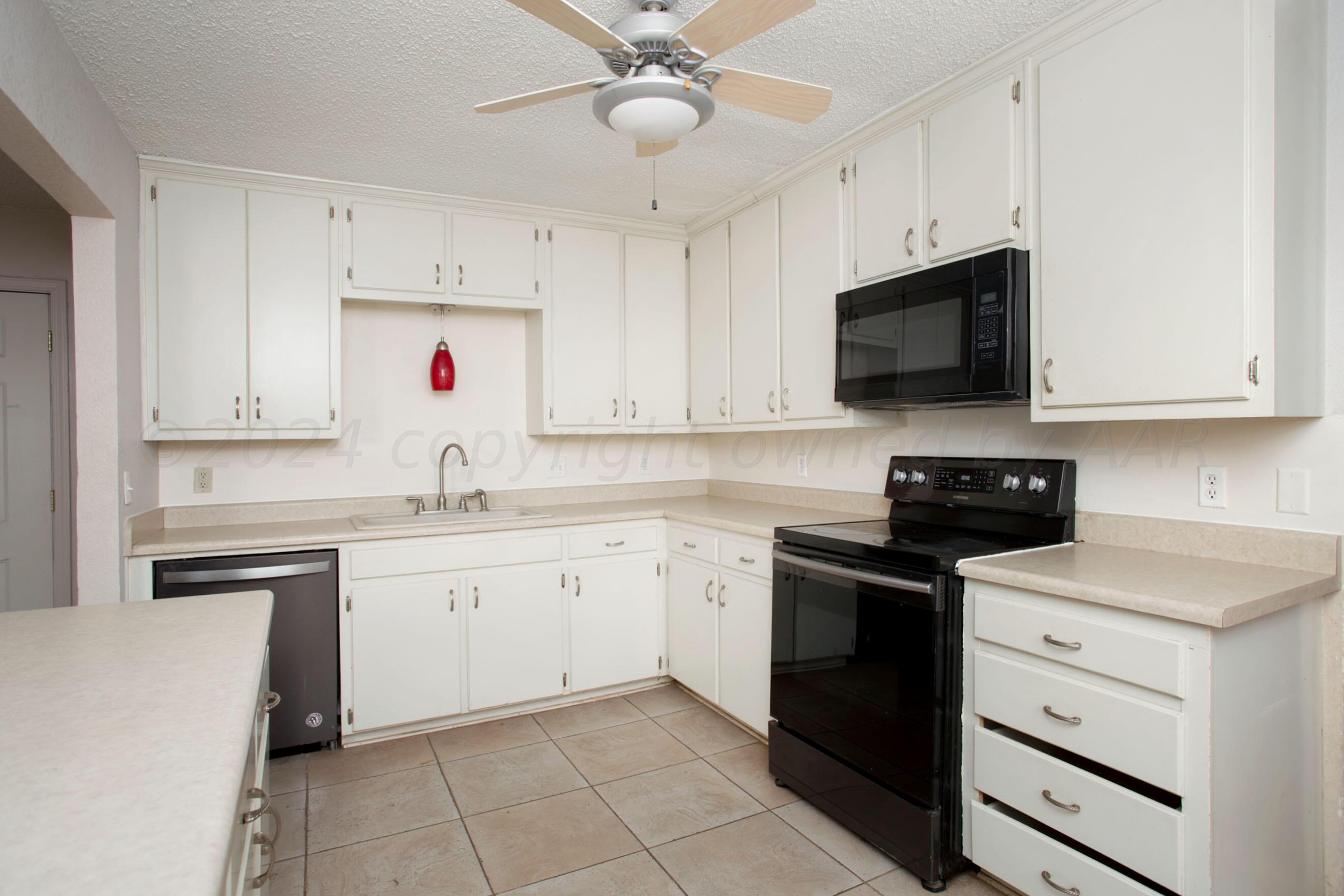 4625 South Travis Street Amarillo, TX 79110 - Photo 8 of 24 a kitchen with cabinets stainless steel appliances and a sink