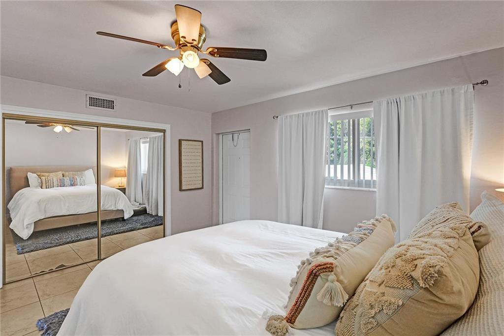 2131 Northeast 40th Court Lighthouse Point, FL 33064 - Photo 12 of 32 a bedroom with a large bed and a chandelier