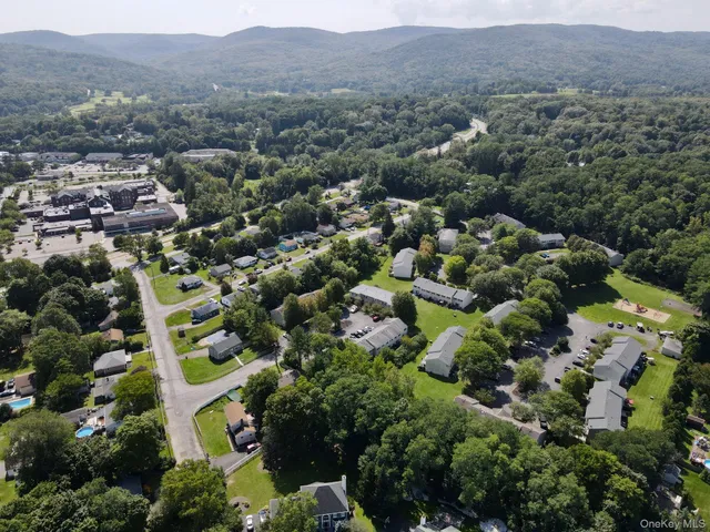 an aerial view of residential houses with outdoor space and trees