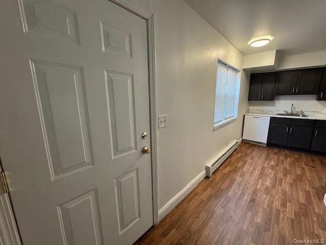 a view of a kitchen with stainless steel appliances wooden floor and cabinets