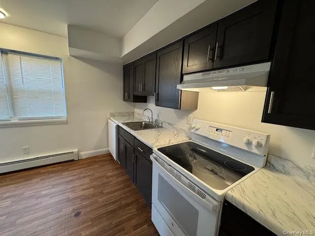 a kitchen with granite countertop a sink stove and cabinets