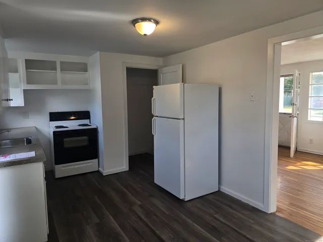 a kitchen with a refrigerator and a stove top oven