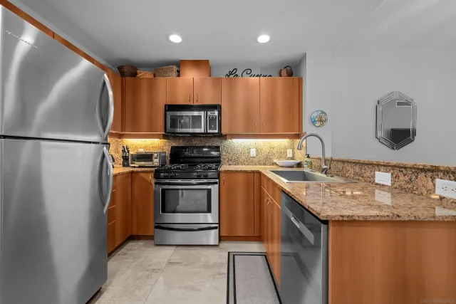 a kitchen with stainless steel appliances granite countertop a refrigerator sink and stove