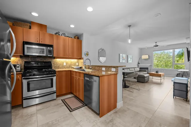 a kitchen with kitchen island granite countertop a stove and a sink