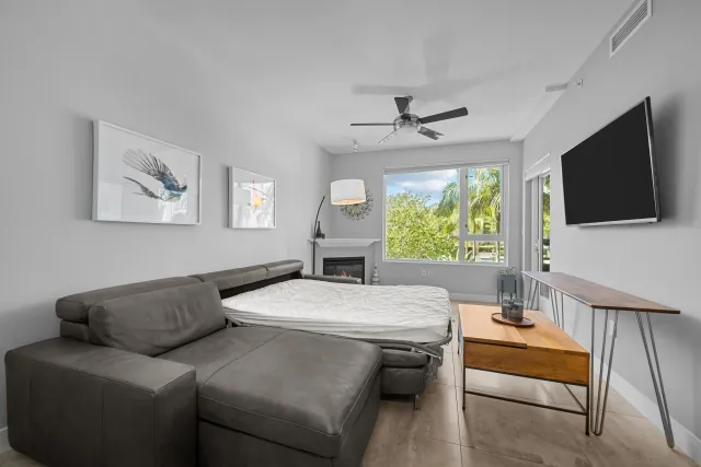 a living room with furniture a flat screen tv and a window