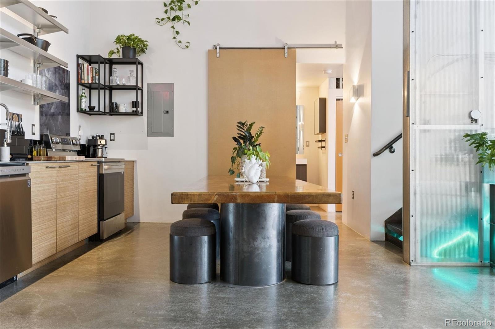 3457 Ringsby Court, Unit 304 Denver, CO 80216 - Photo 11 of 28 a dining hall with stainless steel appliances kitchen island granite countertop a table and chairs in it