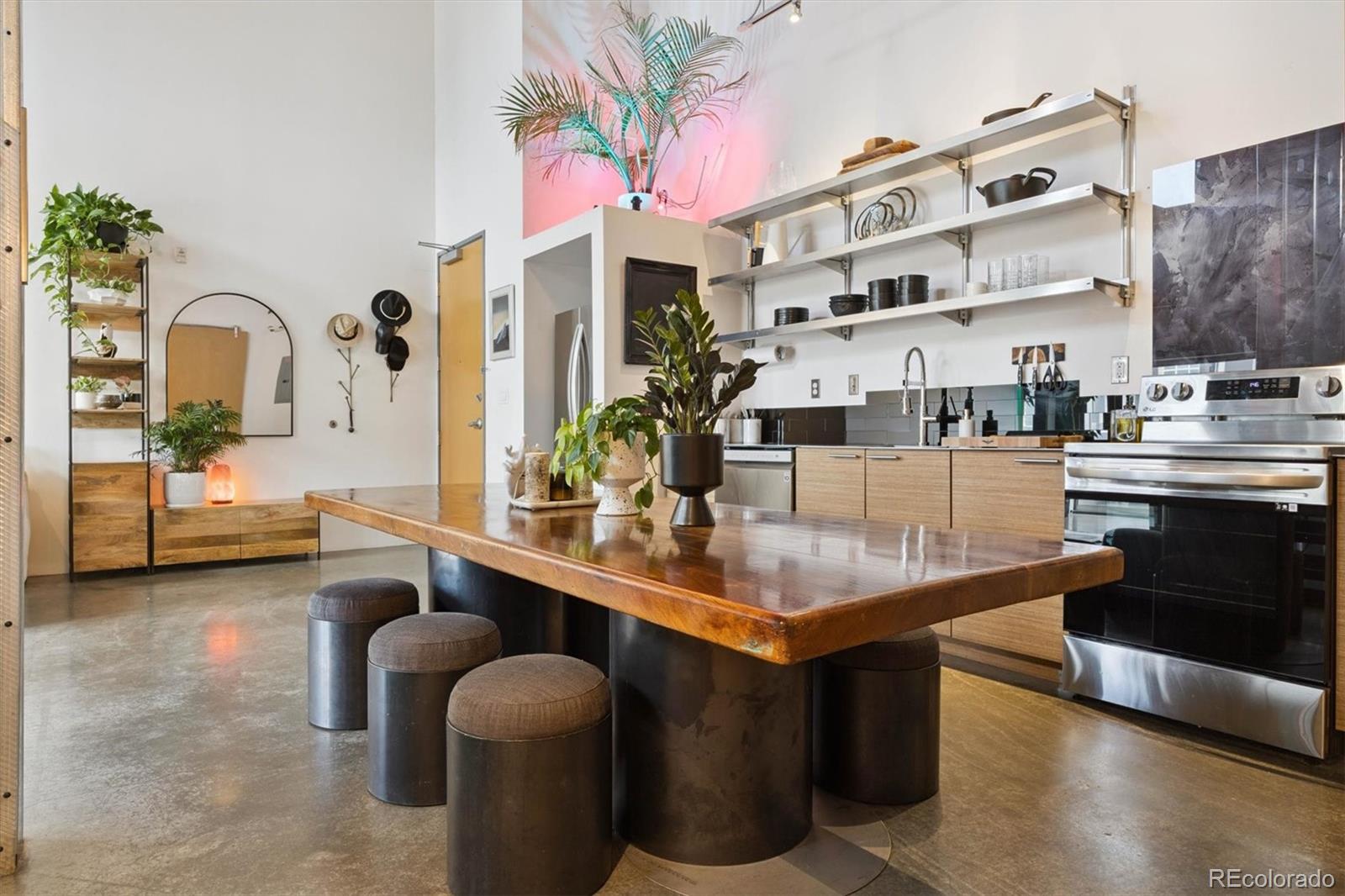3457 Ringsby Court, Unit 304 Denver, CO 80216 - Photo 12 of 28 a kitchen with stainless steel appliances kitchen island granite countertop a sink and cabinets
