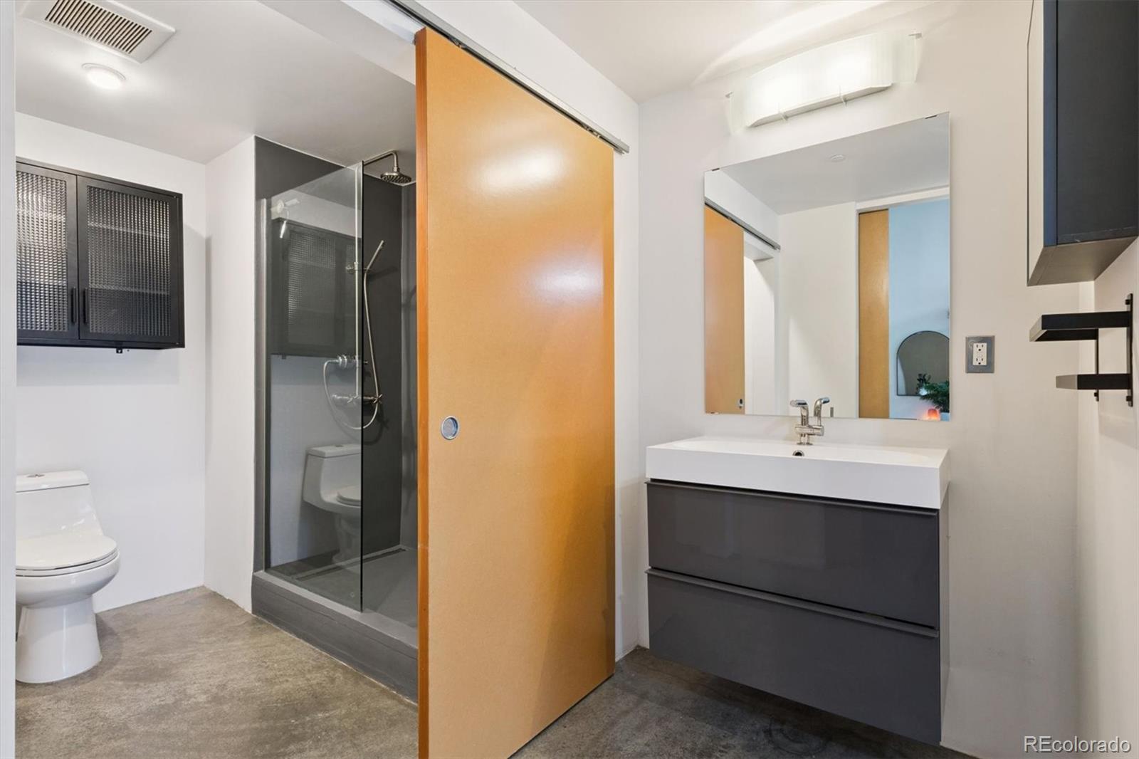 3457 Ringsby Court, Unit 304 Denver, CO 80216 - Photo 14 of 28 a bathroom with a toilet sink and shower