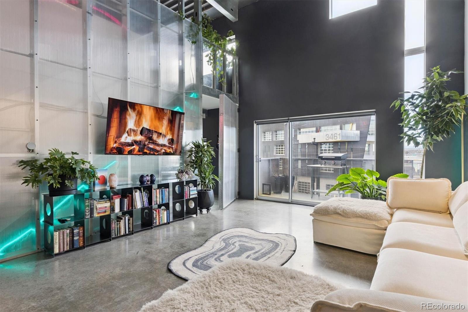 3457 Ringsby Court, Unit 304 Denver, CO 80216 - Photo 5 of 28 a living room with furniture and a flat screen tv