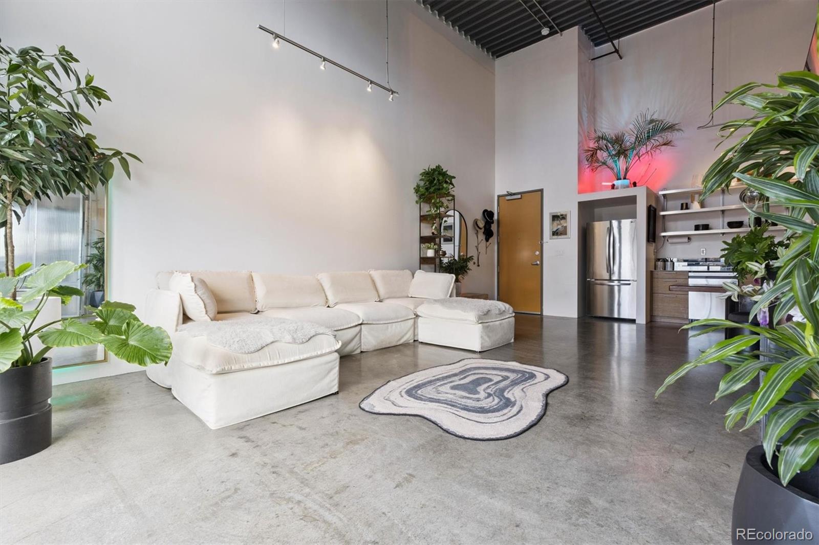 3457 Ringsby Court, Unit 304 Denver, CO 80216 - Photo 6 of 28 a living room with furniture and a potted plant