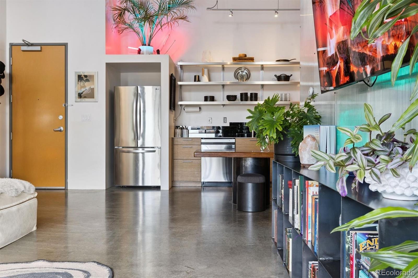 3457 Ringsby Court, Unit 304 Denver, CO 80216 - Photo 7 of 28 a kitchen with stainless steel appliances kitchen island granite countertop a refrigerator a stove and a wooden floor