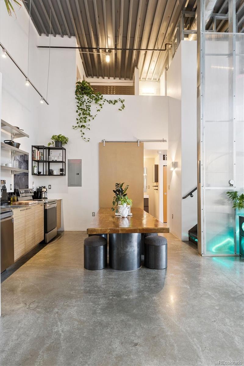 3457 Ringsby Court, Unit 304 Denver, CO 80216 - Photo 10 of 28 a view of a kitchen with kitchen island a counter top space a sink stainless steel appliances and cabinets