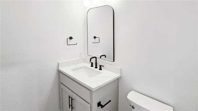 a bathroom with a sink a toilet and mirror