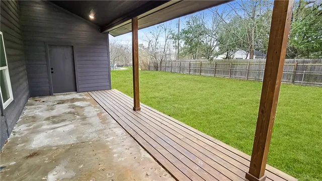 a view of backyard with wooden fence