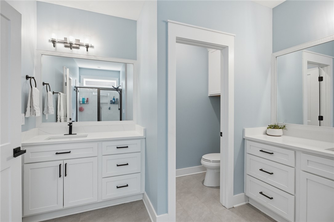 318 Summerall Drive Anderson, SC 29621 - Photo 14 of 42 This bright bathroom features dual vanities and a separate water closet, offering both style and practicality.