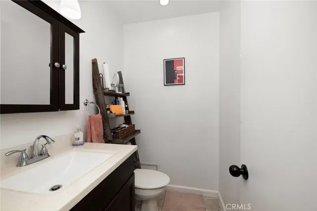 a bathroom with a sink vanity mirror and toilet