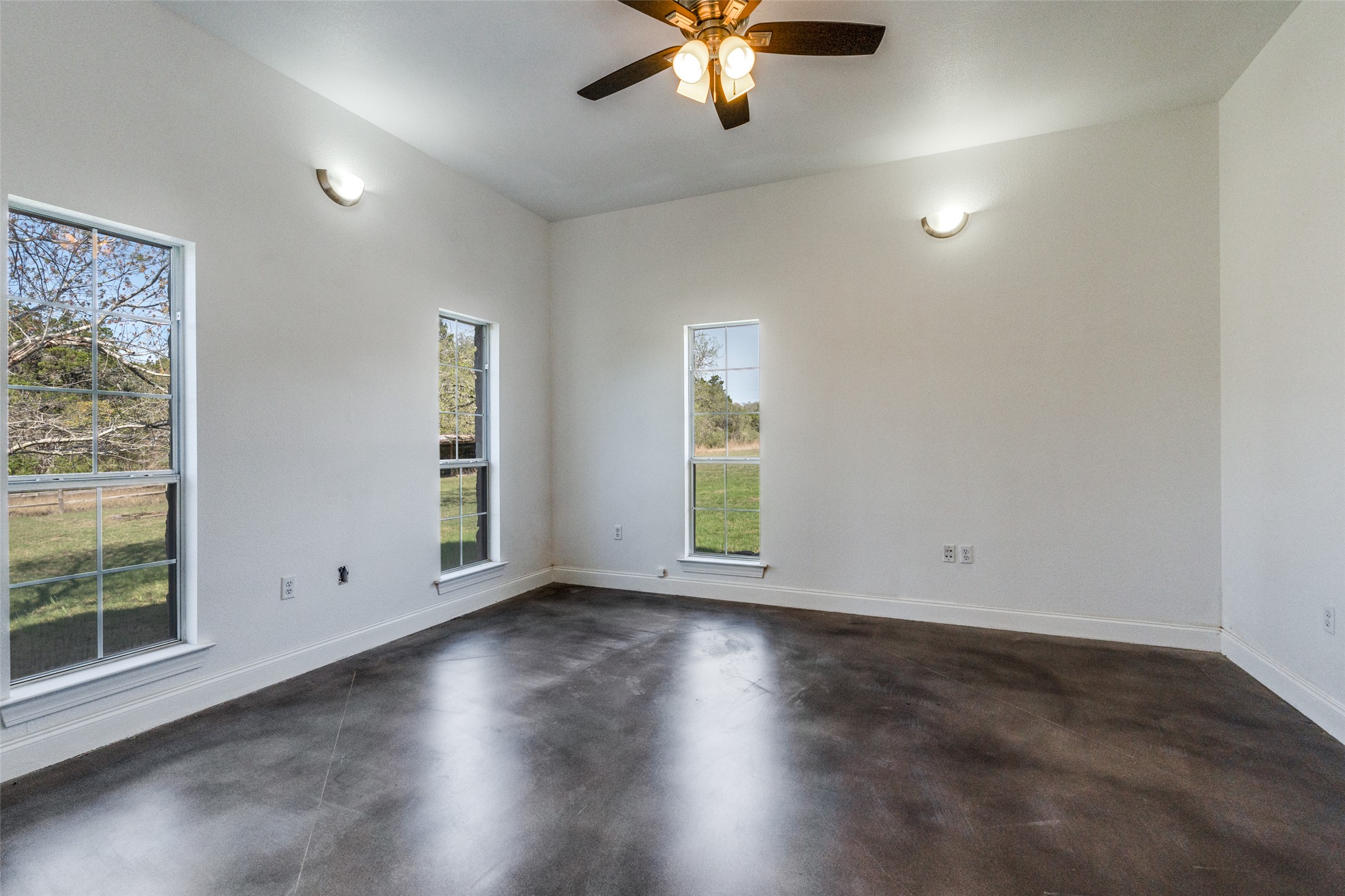 34970 Smithson Valley Road Bulverde, TX 78163 - Photo 16 of 36 an empty room with wooden floor fan and windows