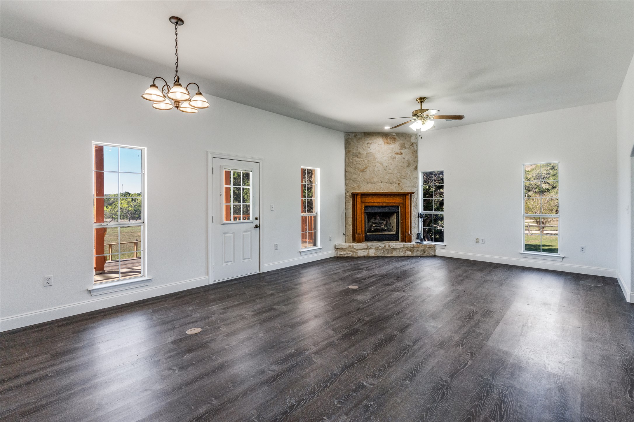 34970 Smithson Valley Road Bulverde, TX 78163 - Photo 3 of 36 an empty room with wooden floor fireplace and windows