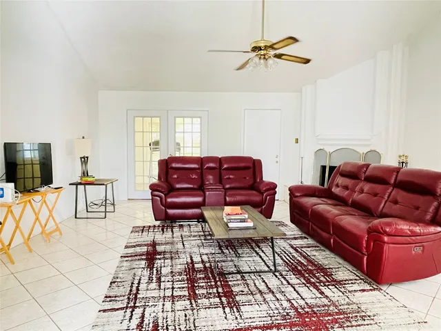 a living room with furniture a flat screen tv and a window