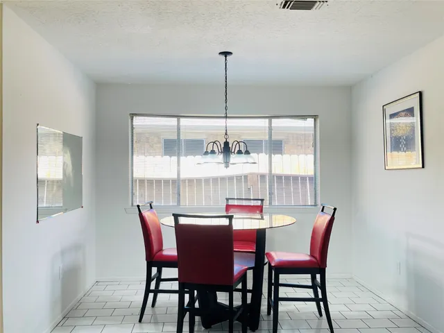 a dining room with furniture a chandelier and window