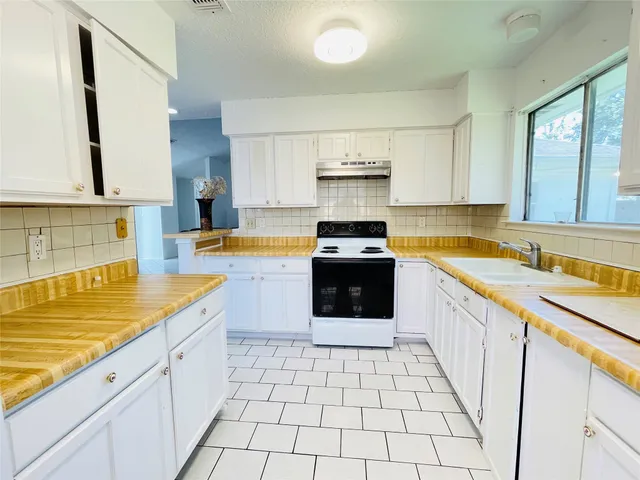 a kitchen with a stove sink and cabinets