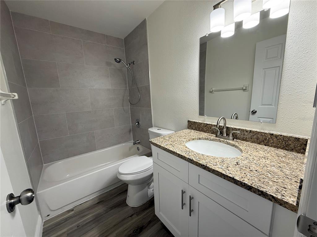 9209 Tudor Drive, Unit C102 Tampa, FL 33615 - Photo 5 of 8 a bathroom with a granite countertop sink toilet and shower