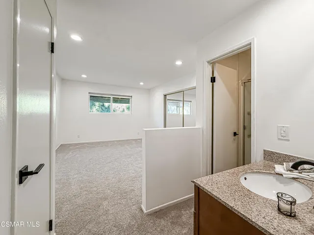 a bathroom with a granite countertop sink a toilet and shower