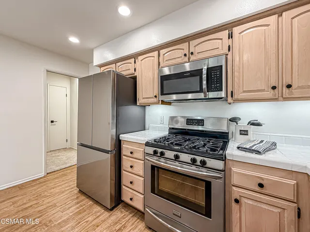 a kitchen with stainless steel appliances granite countertop a stove a microwave and a refrigerator