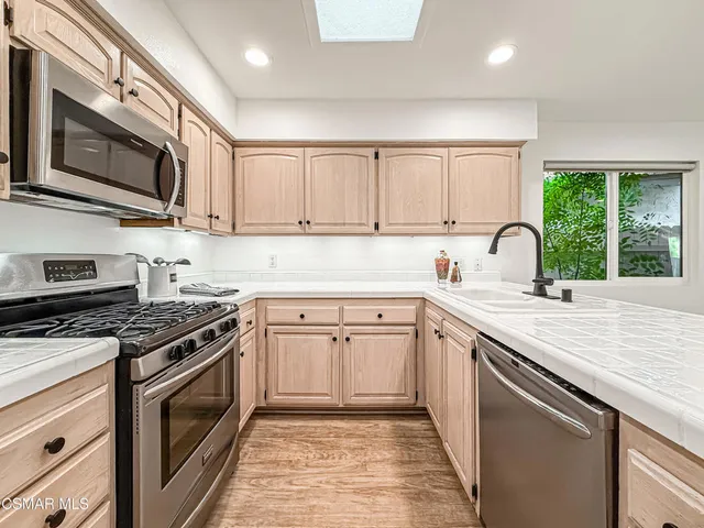 a kitchen with stainless steel appliances granite countertop a stove sink microwave and cabinets