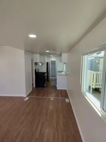 a view of a big room with wooden floor and windows