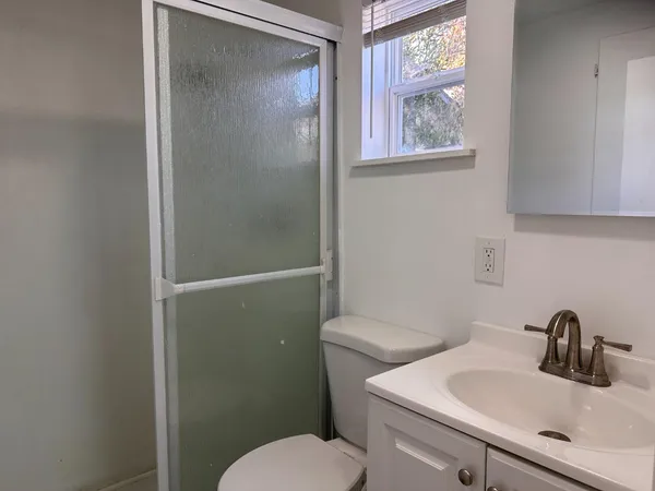 a bathroom with a toilet a sink and a window