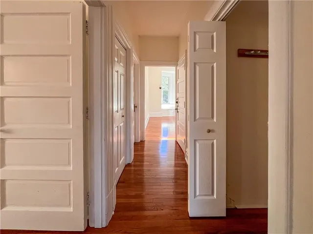 a view of a hallway with wooden floor and closet