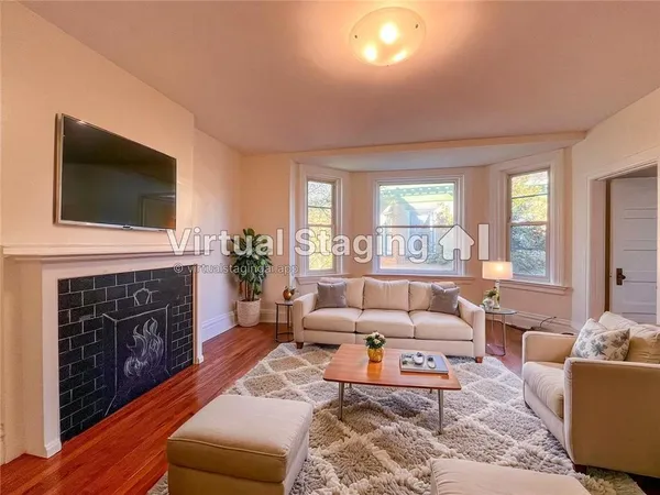 a living room with furniture a fireplace and a flat screen tv