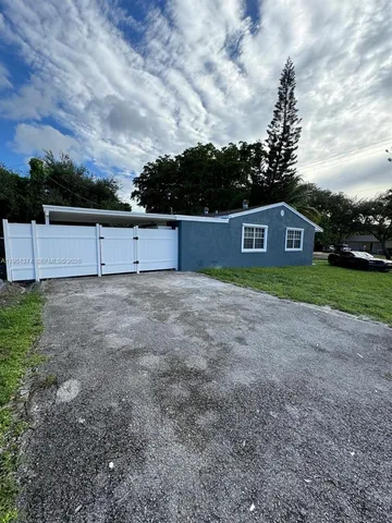 a view of a yard with wooden fence