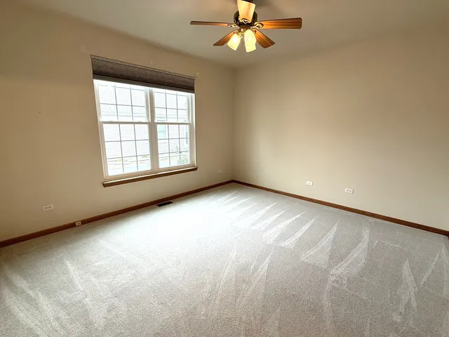 an empty room with a window and a fan