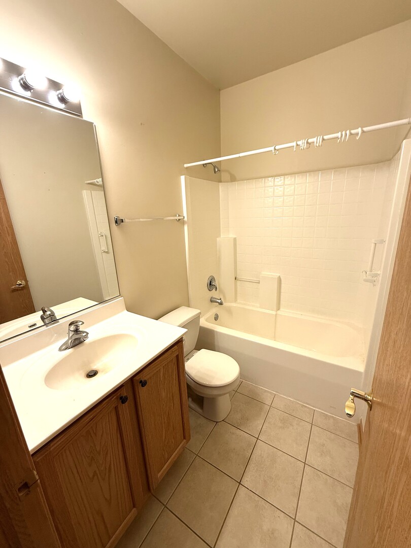 1604 Augusta Lane Shorewood, IL 60404 - Photo 18 of 32 a bathroom with a sink a toilet and shower