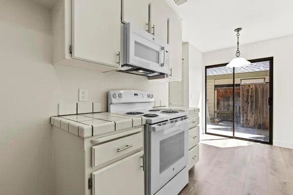 a white stove top oven sitting inside of a kitchen