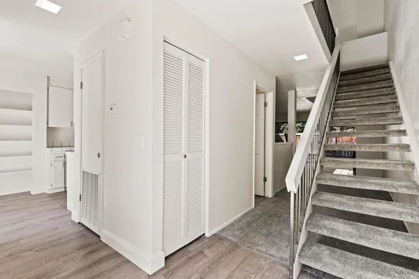 a view of a hallway with wooden floor and entryway