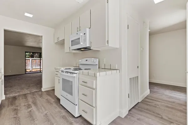 a kitchen with stainless steel appliances granite countertop a sink stove and cabinets