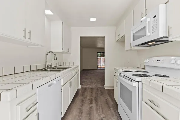 a kitchen with stove cabinets and fan