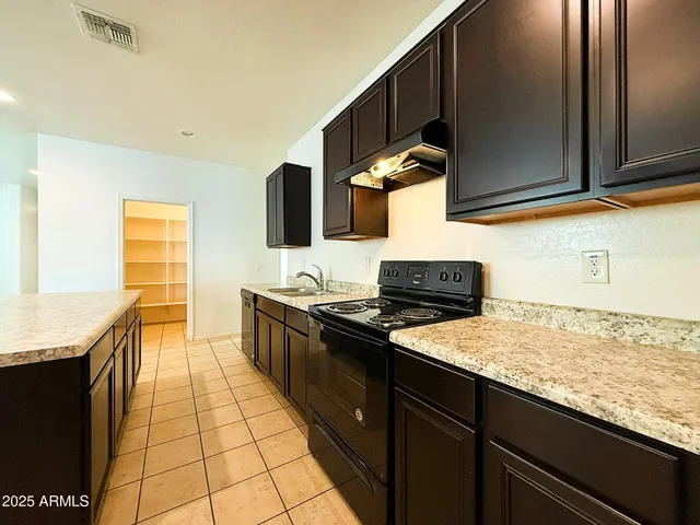a kitchen with stainless steel appliances granite countertop a stove a sink and a microwave