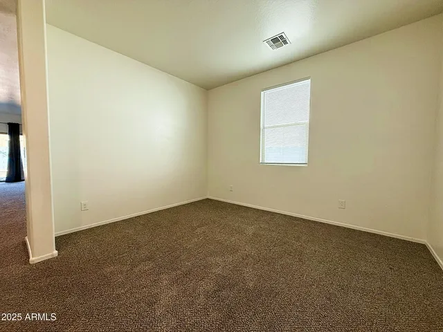en empty room with windows and ceiling fan