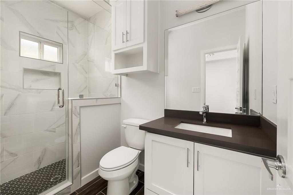1322 Beverly Avenue Weslaco, TX 78596 - Photo 11 of 17 a bathroom with a granite countertop sink toilet and shower