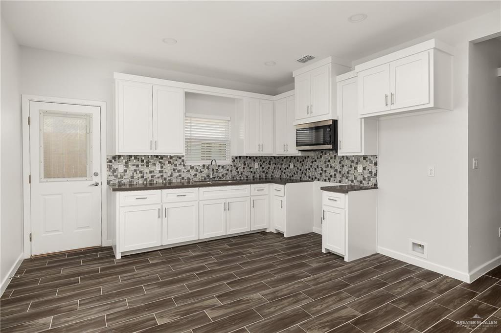 1322 Beverly Avenue Weslaco, TX 78596 - Photo 5 of 17 a kitchen with granite countertop a sink and cabinets