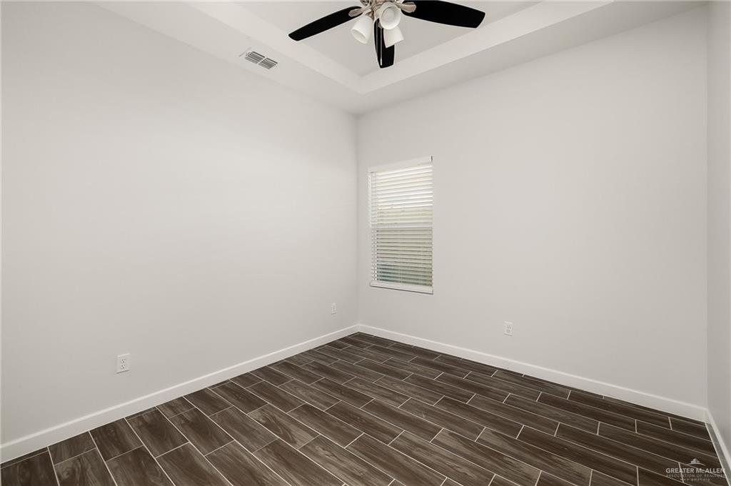 1322 Beverly Avenue Weslaco, TX 78596 - Photo 8 of 17 an empty room with wooden floor and windows