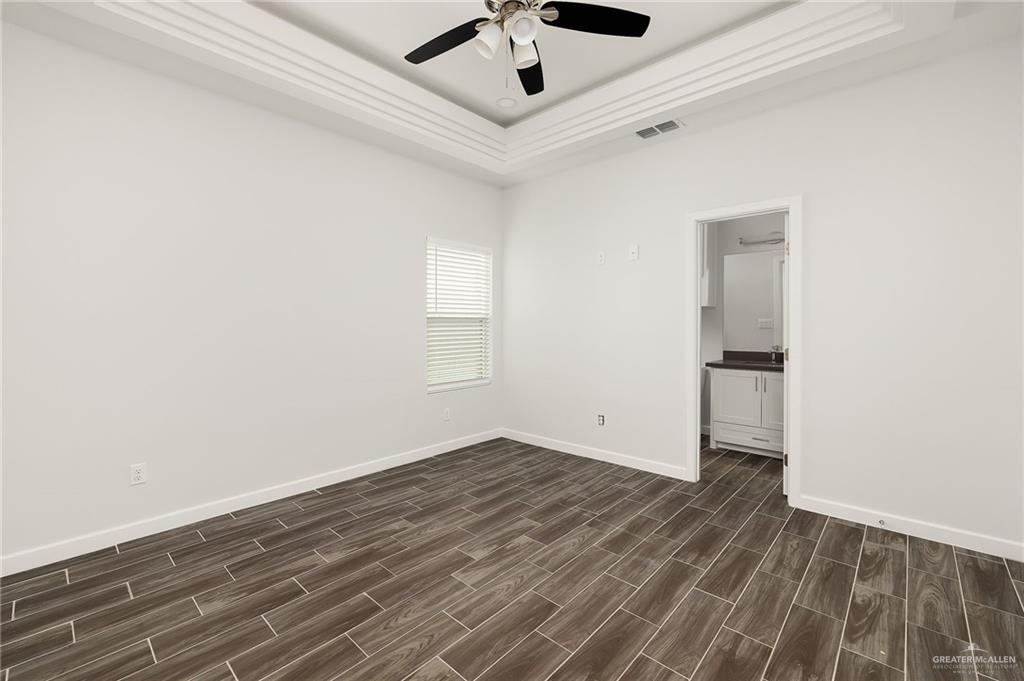 1322 Beverly Avenue Weslaco, TX 78596 - Photo 10 of 17 an empty room with a ceiling fan and wooden floor