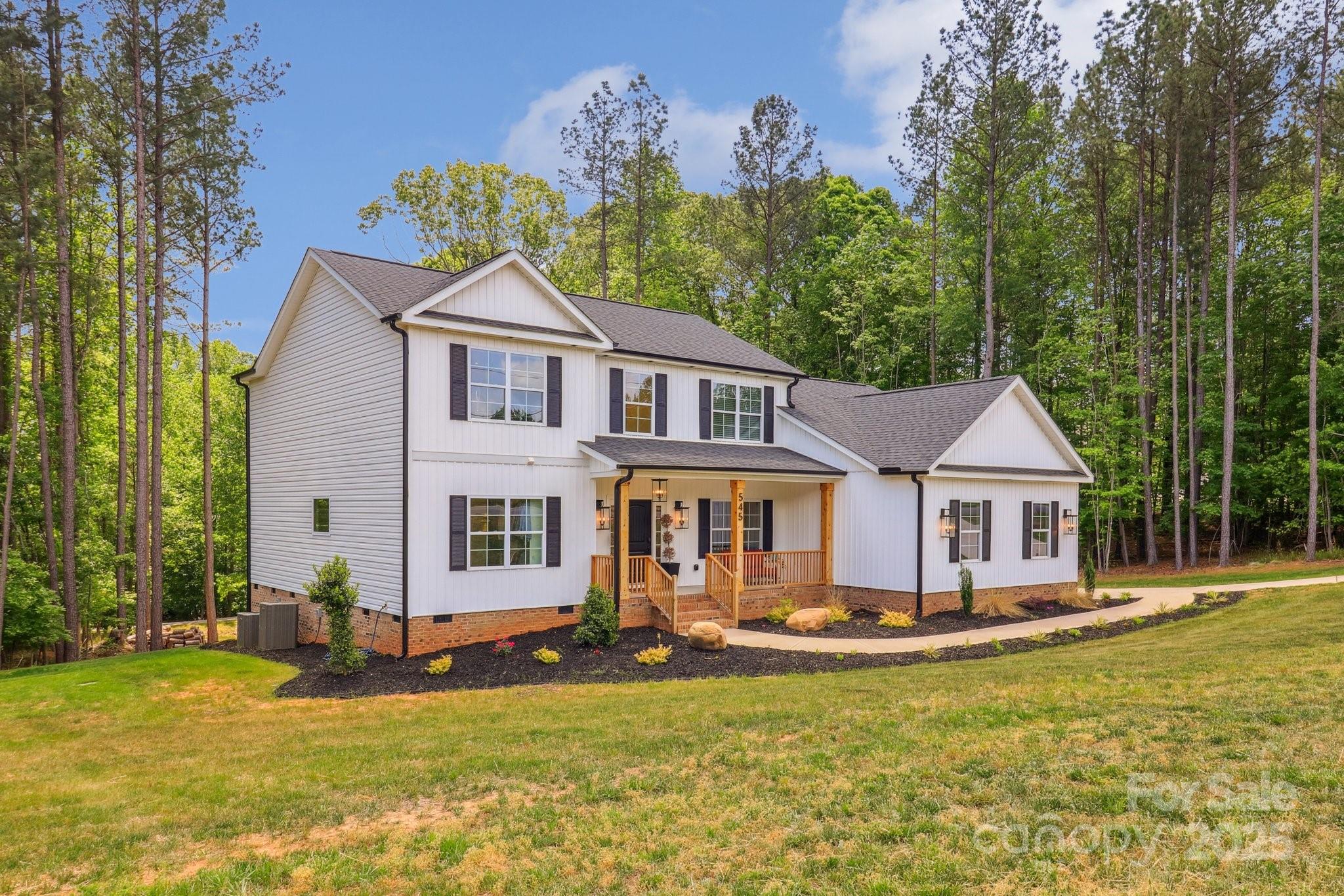 545 Morrison Farm Road Troutman, NC 28166 - Photo 1 of 31 a front view of a house with a yard table and chairs