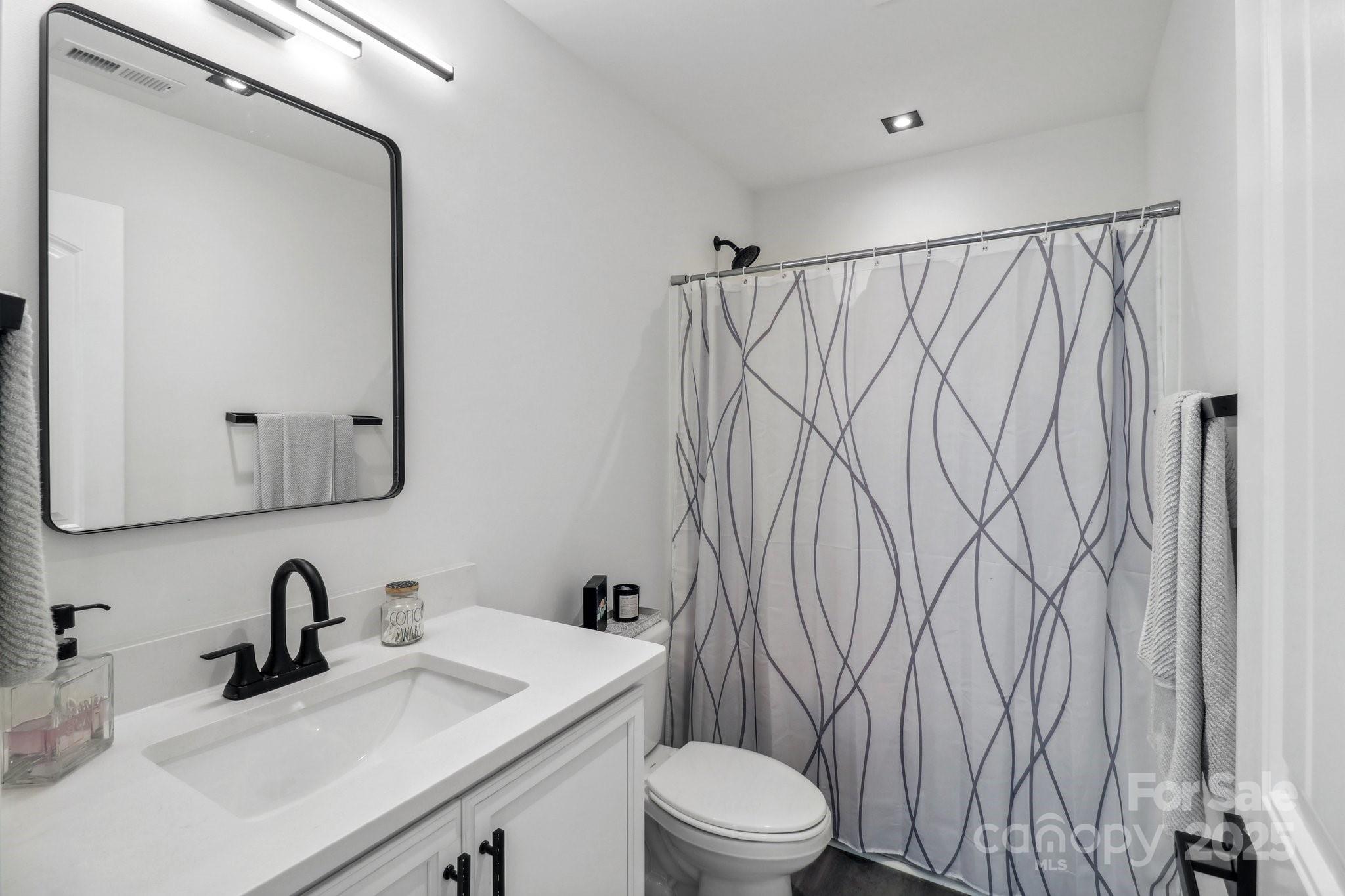 545 Morrison Farm Road Troutman, NC 28166 - Photo 24 of 31 a bathroom with a sink vanity mirror and toilet
